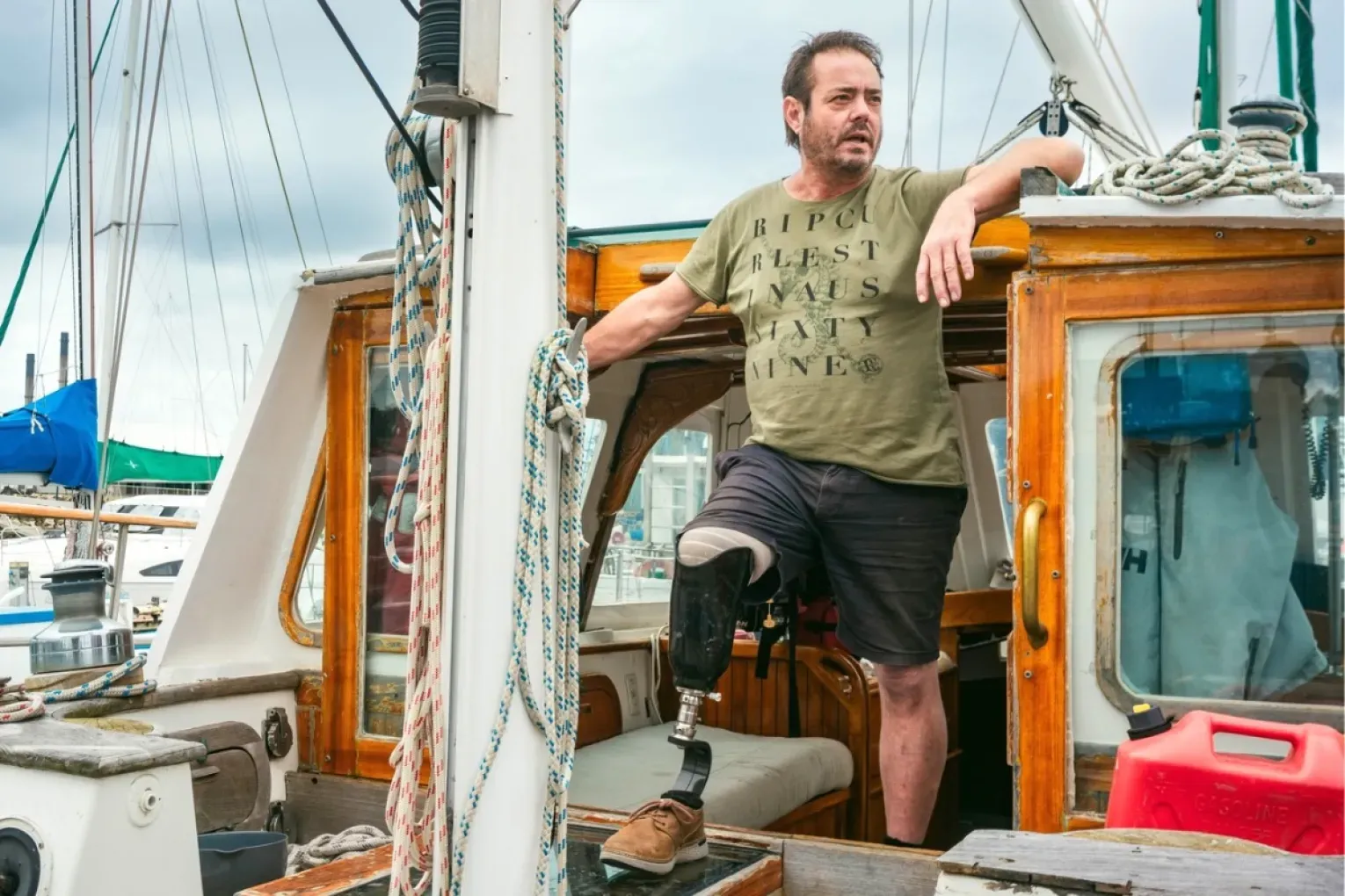 Tim on Sea Dragon's deck in front of the doghouse, prosthetic leg visible